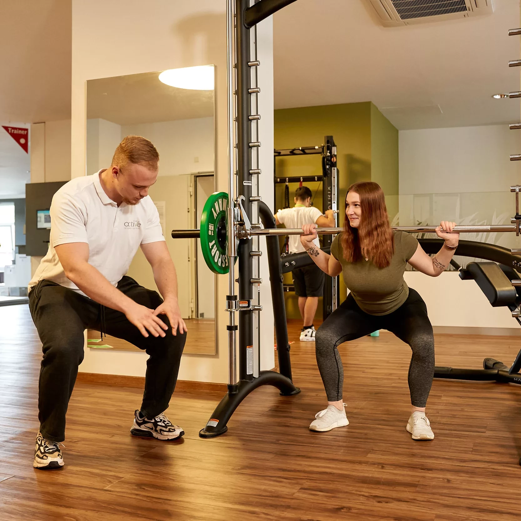 Frau wird beim Training von einem Trainer korrigiert